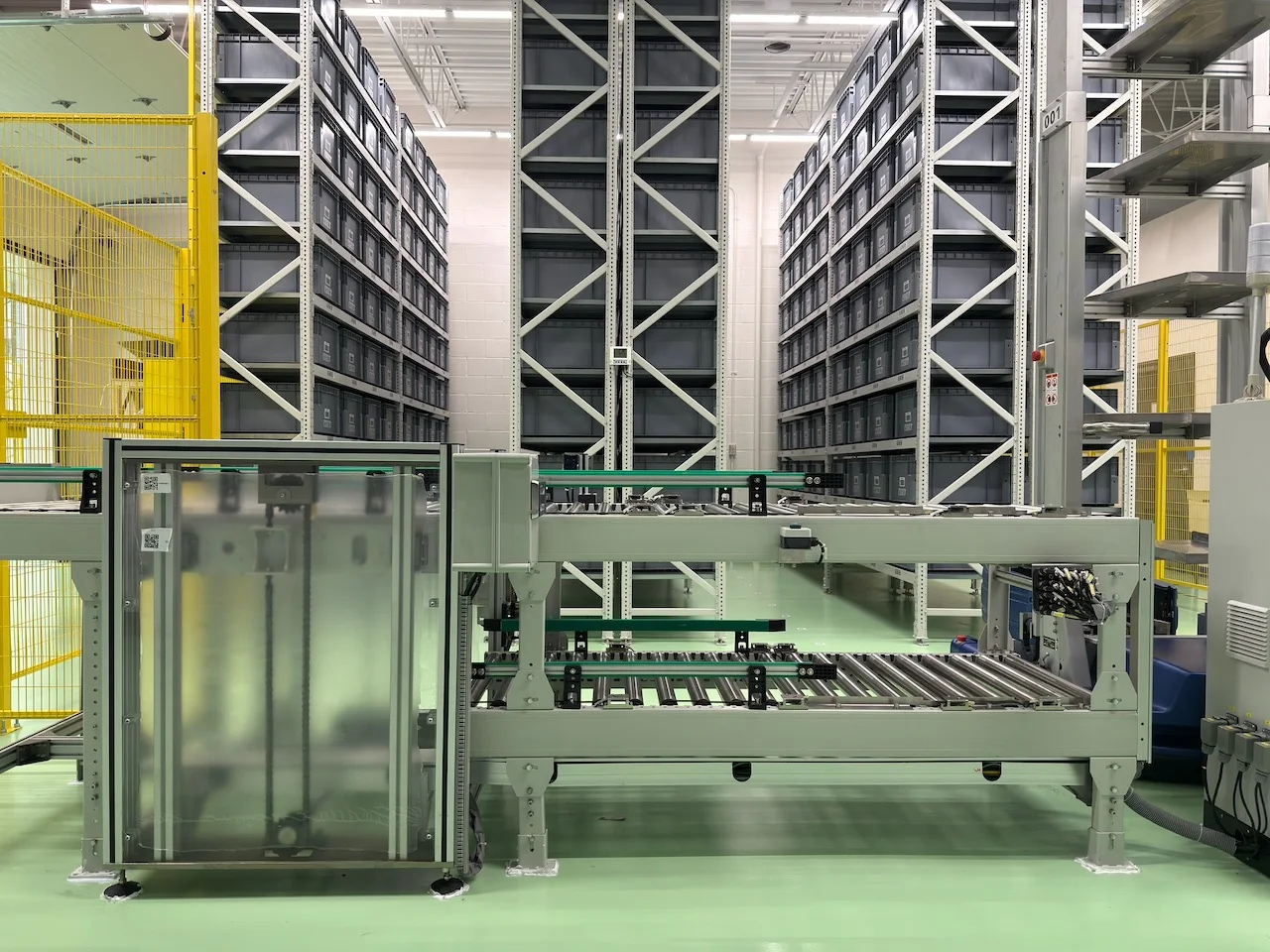 Automated warehouse with high-bay storage, conveyors and robotic retrieval equipment